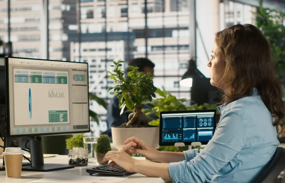 Accountant in busy modern startup agency imputing financial figures on PC